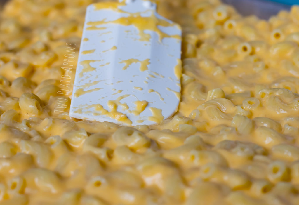 mac and cheese being spread out with a rubber spatula