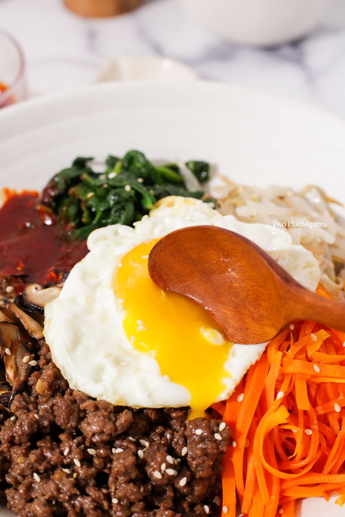 Egg yolk was popped and flowing into the bowl of bibimbap.