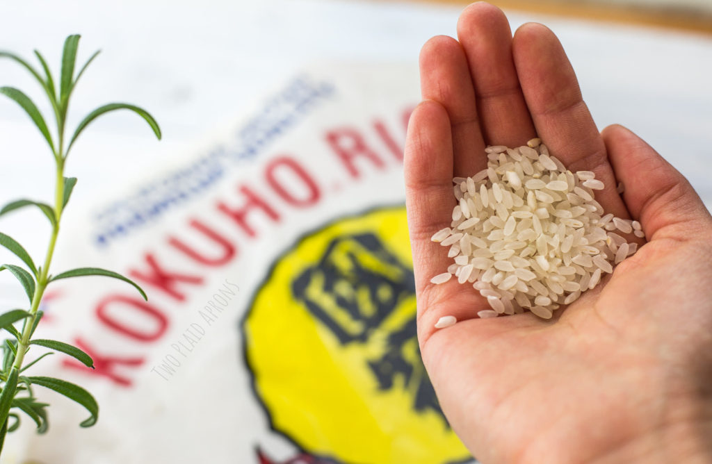 Kokuho brand medium grain white rice in my hand with brand bag in background.