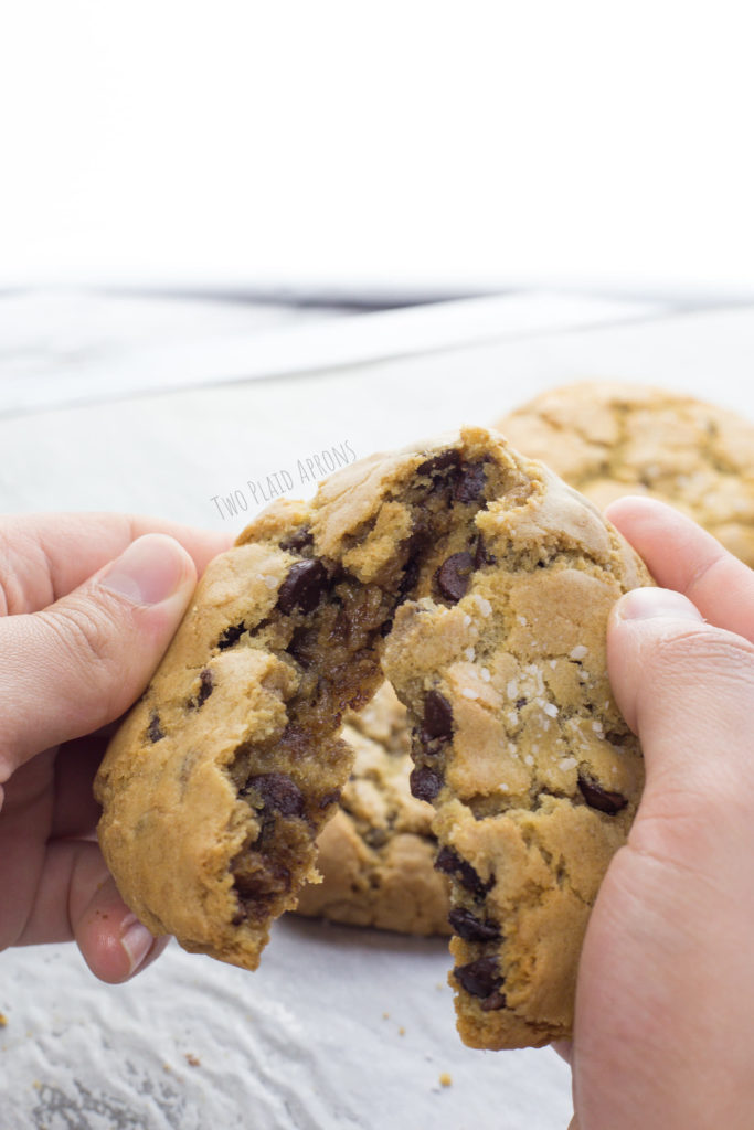 Breaking a chocolate chip cookie in half.
