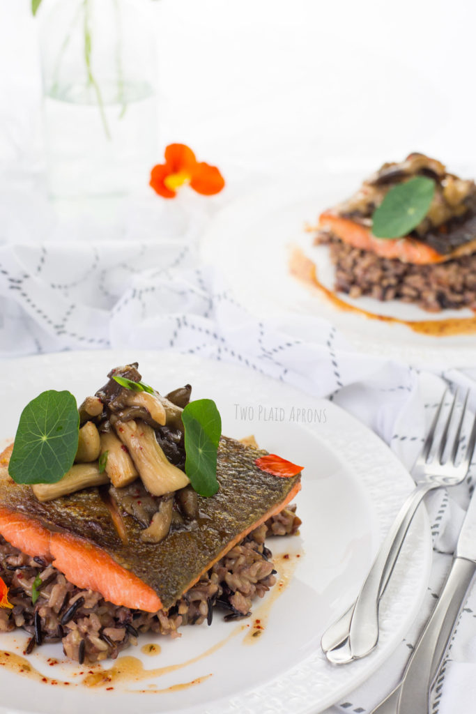 Plated pan-seared salmon with marinated mushrooms and coconut wild rice.