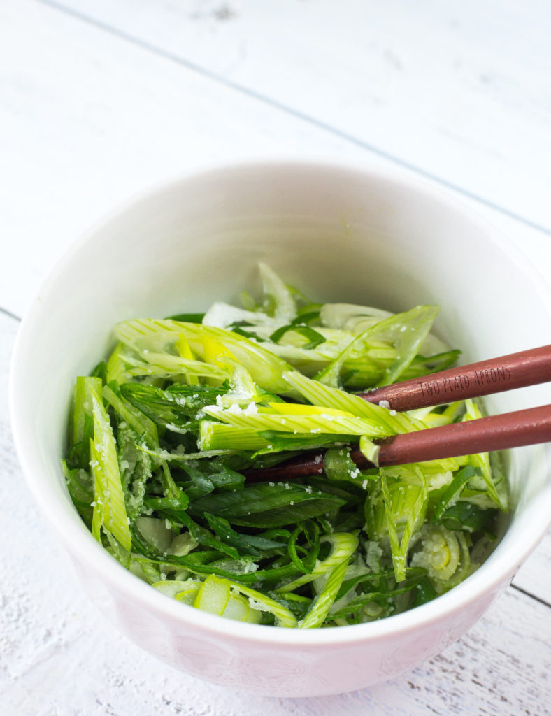 Salting sliced green onions for marinade.