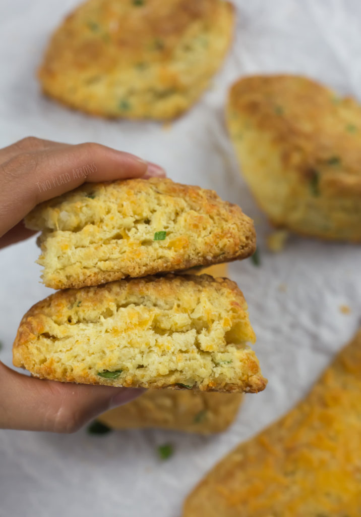 Holding two halves of cheddar green onion scones in left hand.