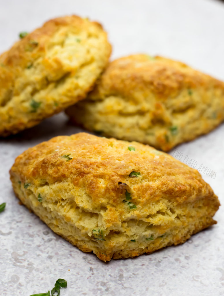 Three cheddar green onion scones semi stacked.