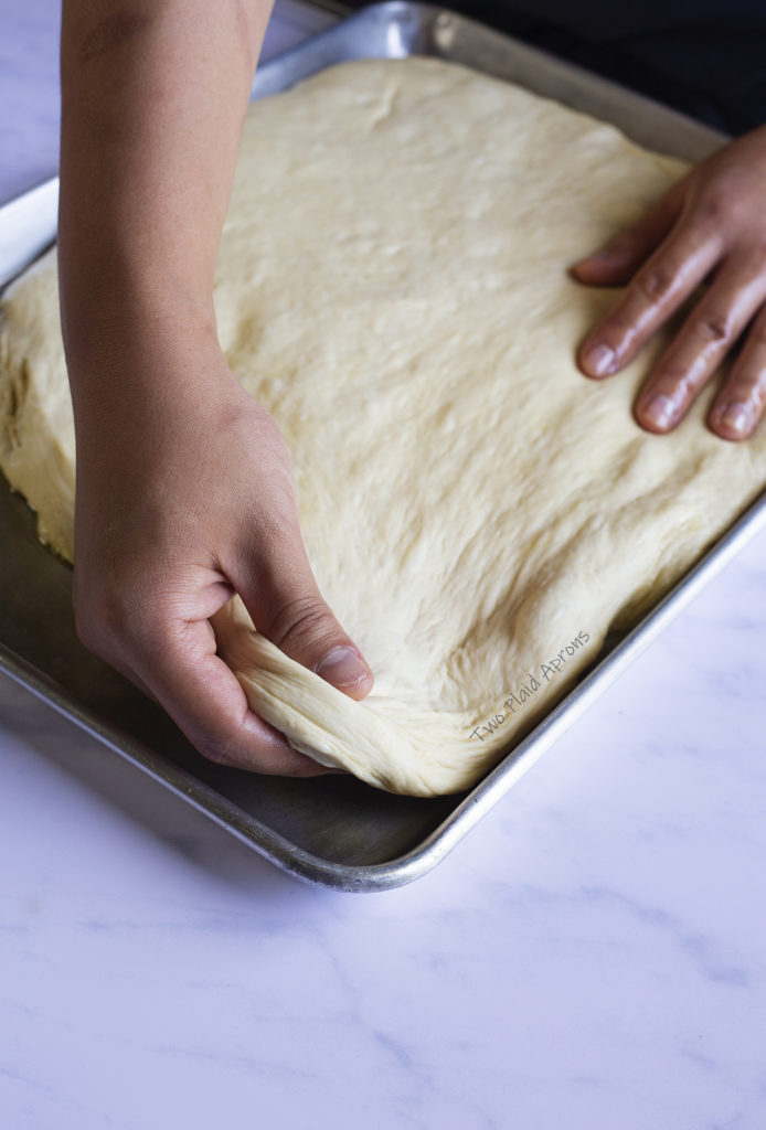 Stretching the dough to fill the whole ½ sheet pan.