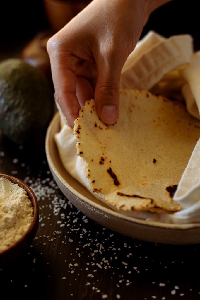 Picking up a freshly made 3 ingredient corn tortilla.