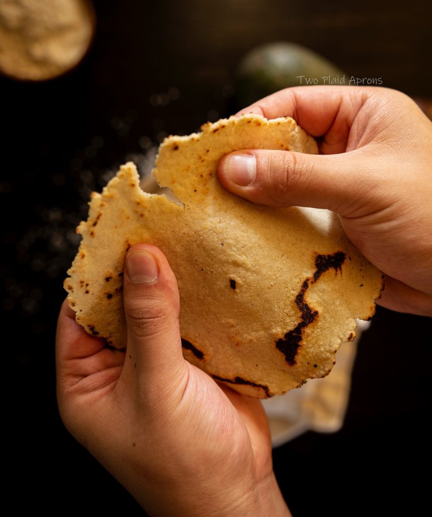 Tearing a corn tortilla in half.