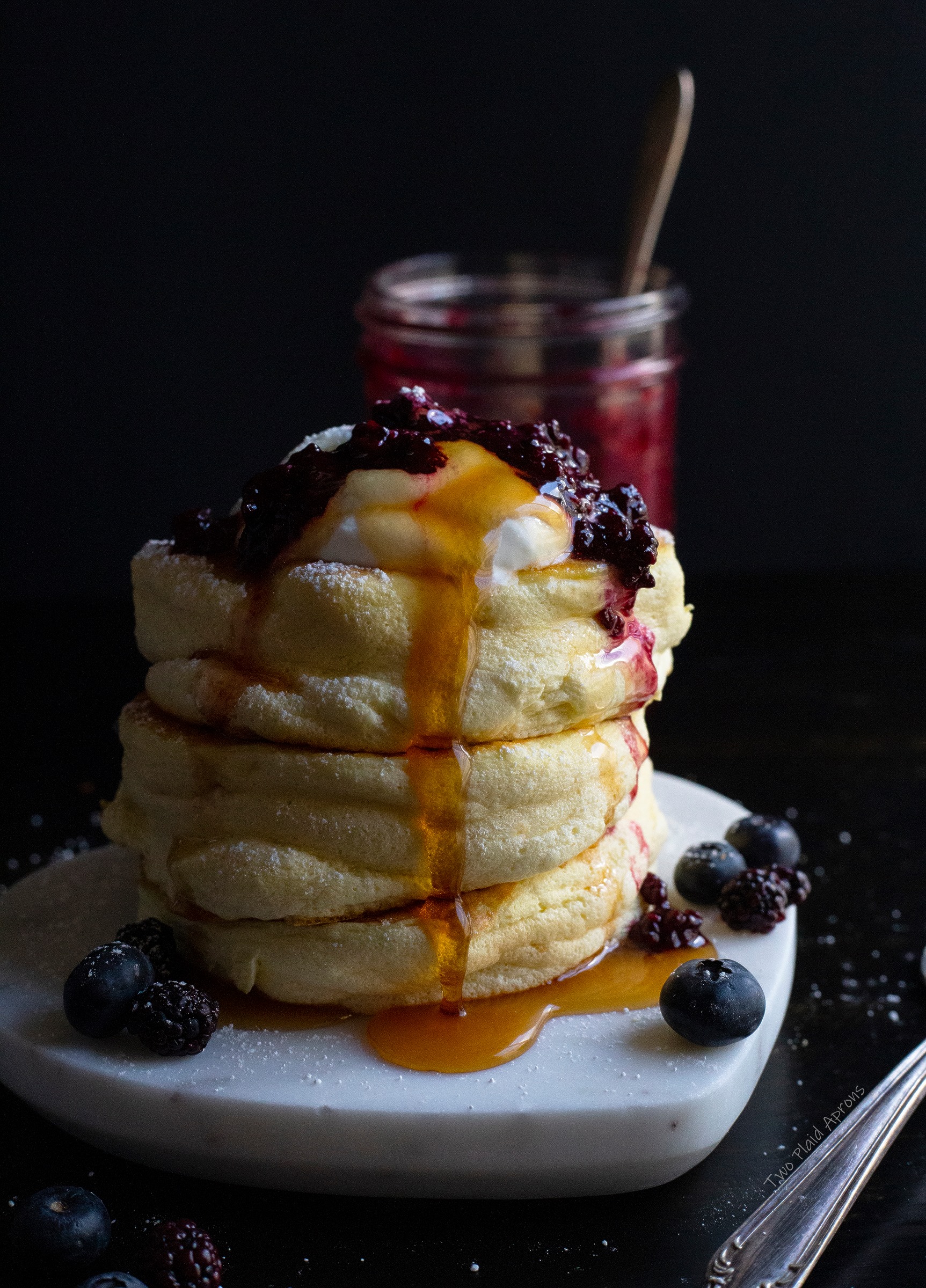 Our jiggly Japanese soufflé pancakes topped with whipped cream, blackberry compote, powdered sugar, and maple syrup.
