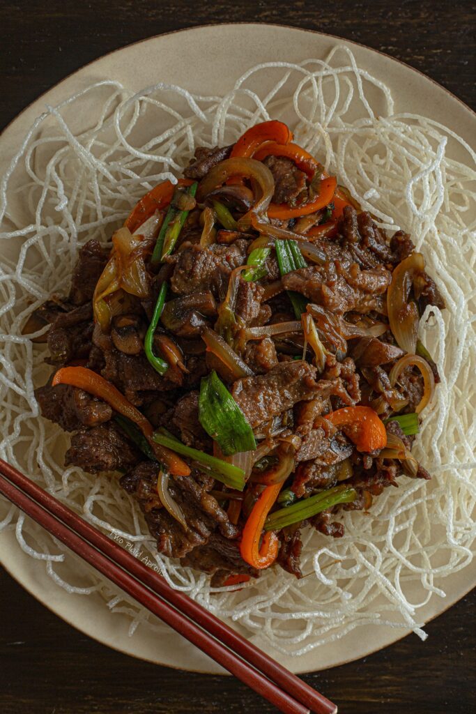 Top down, close view of our restaurant style Mongolian beef on a bed of fried vermicelli.
