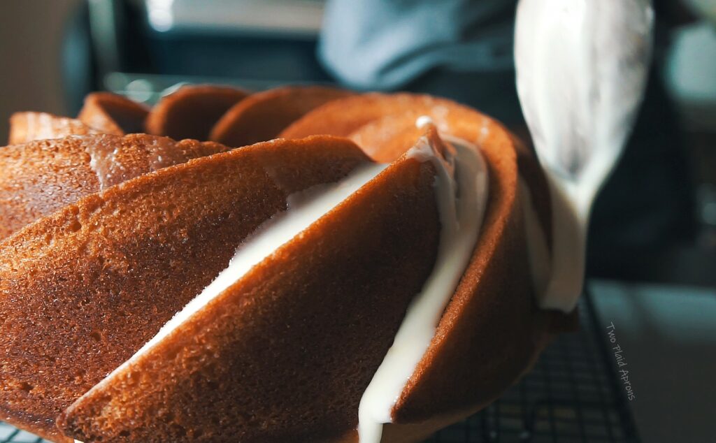 Drizzling the orange olive oil bundt cake with icing.