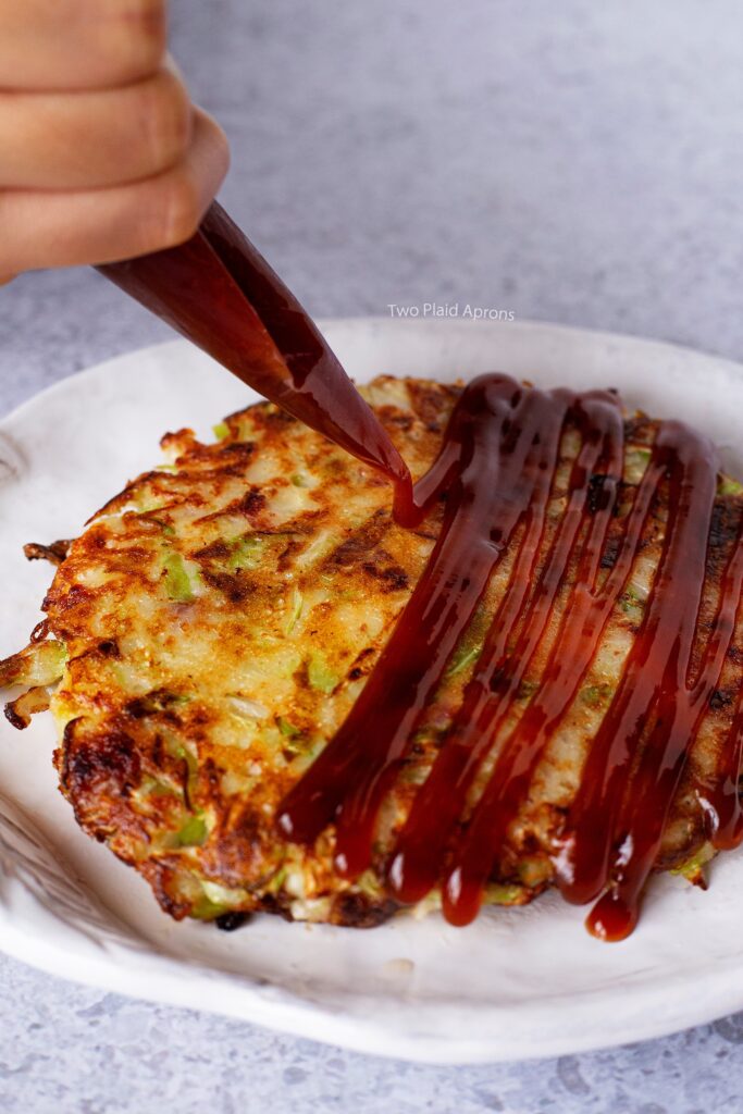 Drizzling Okonomiyaki sauce on the pancake.