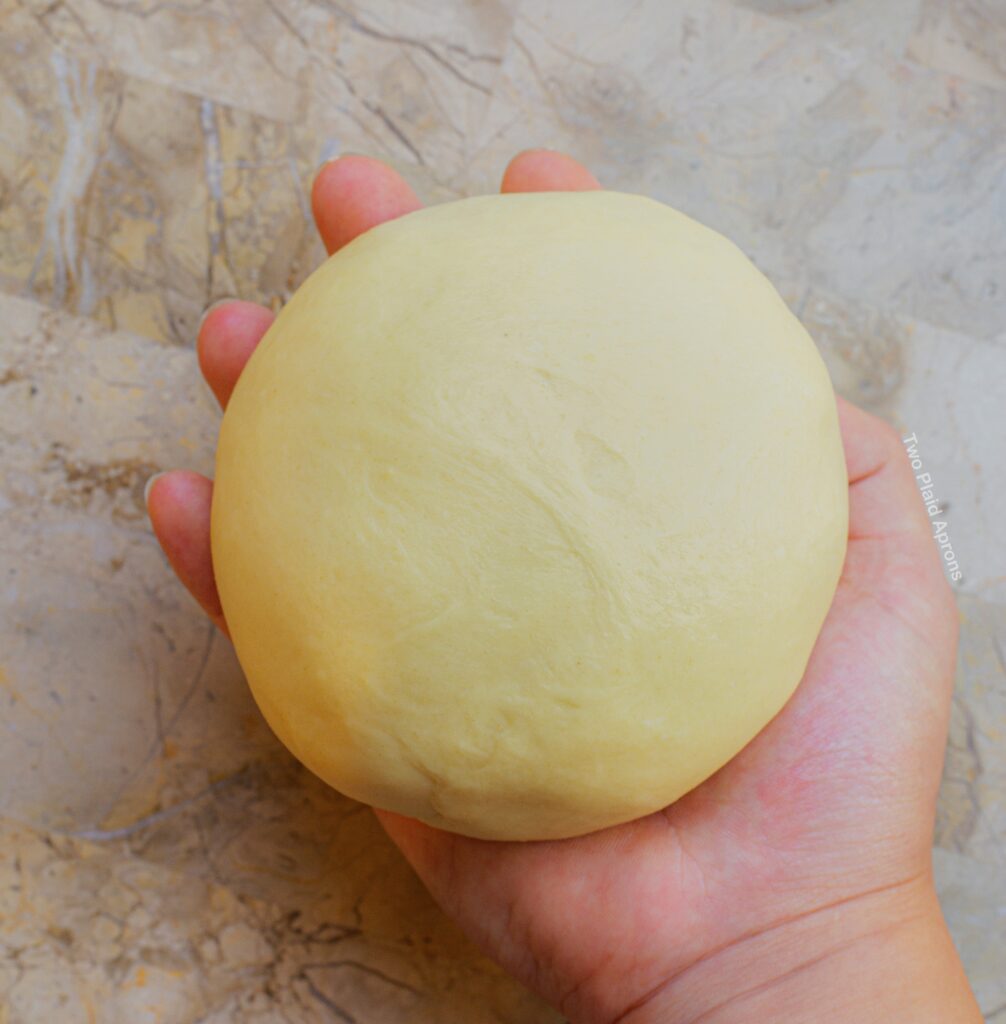 Finished brioche dough smoothed into a ball.