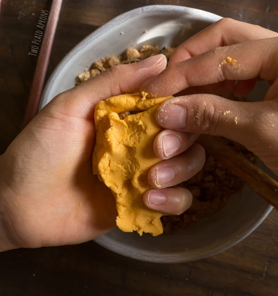 Sealing the sweet potato mochi by pinching the edges of the dough together.