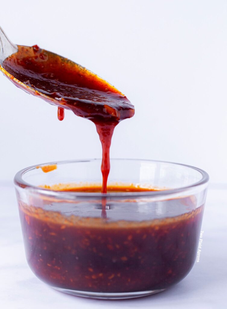 Prepared Korean Fried Chicken Wing sauce dribbling from a spoon.