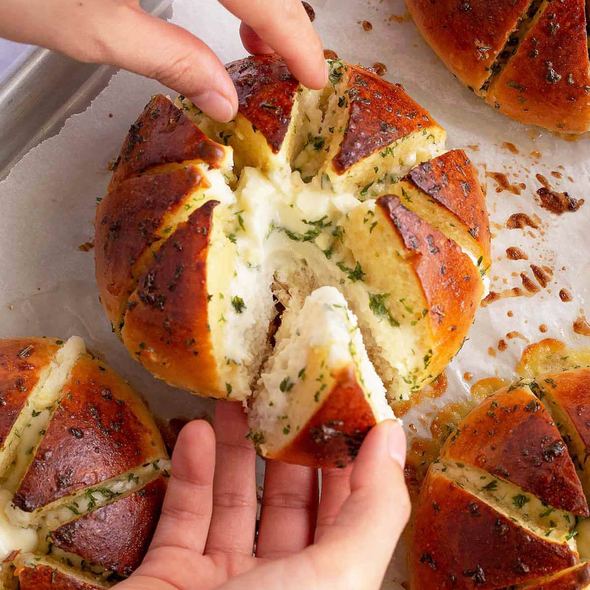 https://twoplaidaprons.com/wp-content/uploads/2020/07/Korean-cream-cheese-garlic-bread-tearing-a-wedge-of-the-baked-garlic-bread.jpg