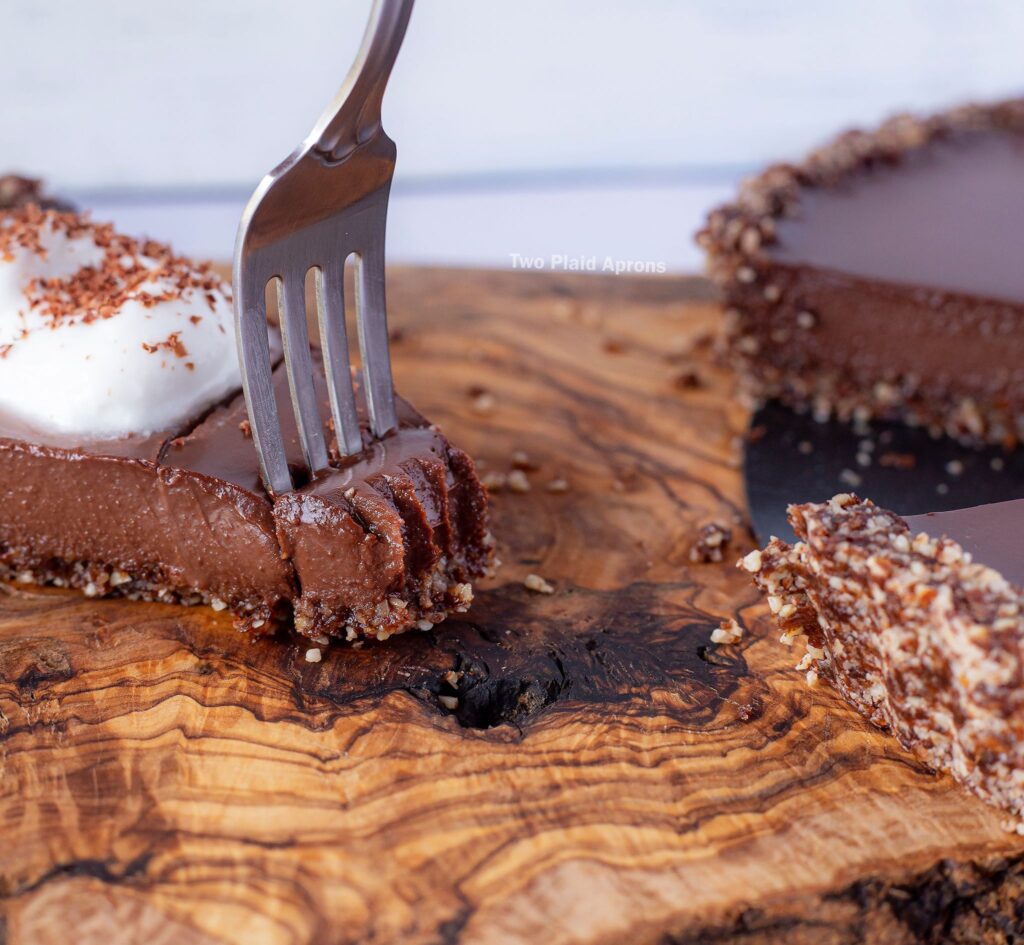 Taking a forkful of chocolate tart from a slice.