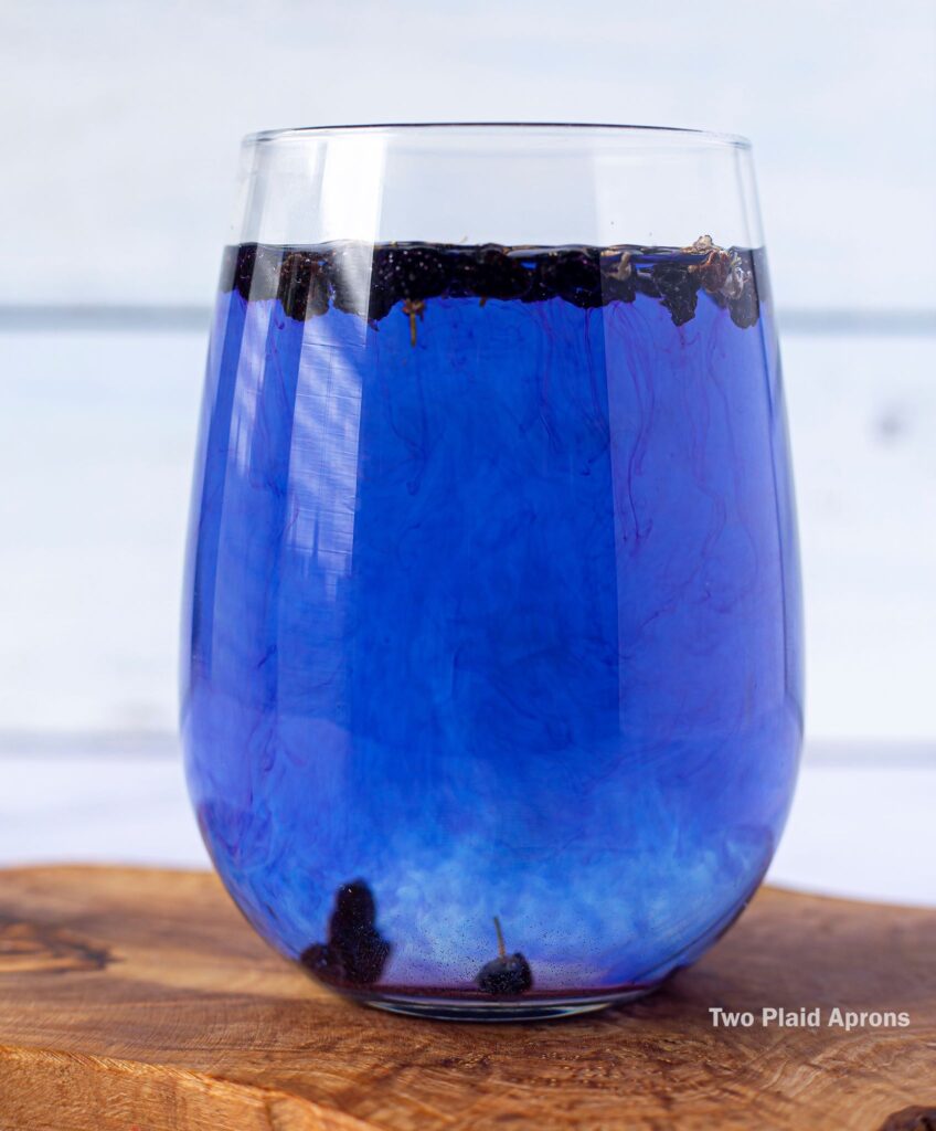 A glass of black wolfberry tea turning completely royal blue.