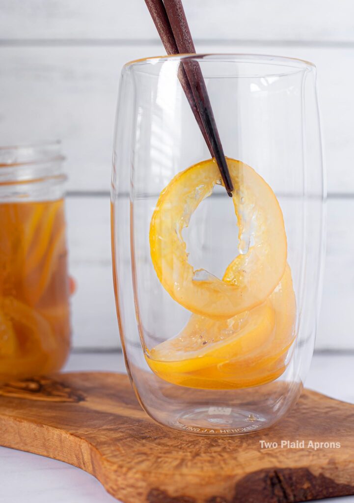 Placing candied lemon into a glass cup.