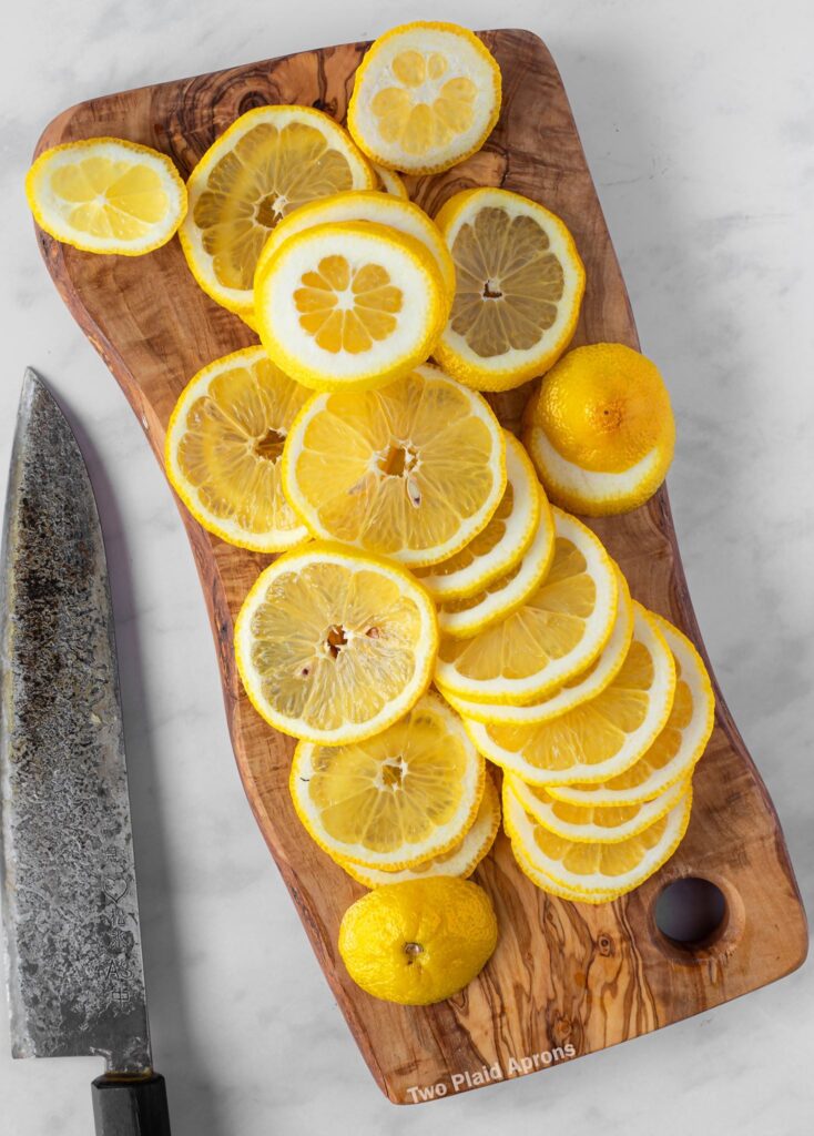 Thinly sliced lemons on a cutting board.