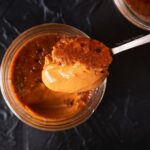 Close up top down view of Thai tea crème brûlée with a spoonful scooped out.
