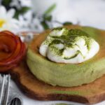 Close up view of our one egg matcha soufflé pancake garnished with whipped cream and matcha powder.
