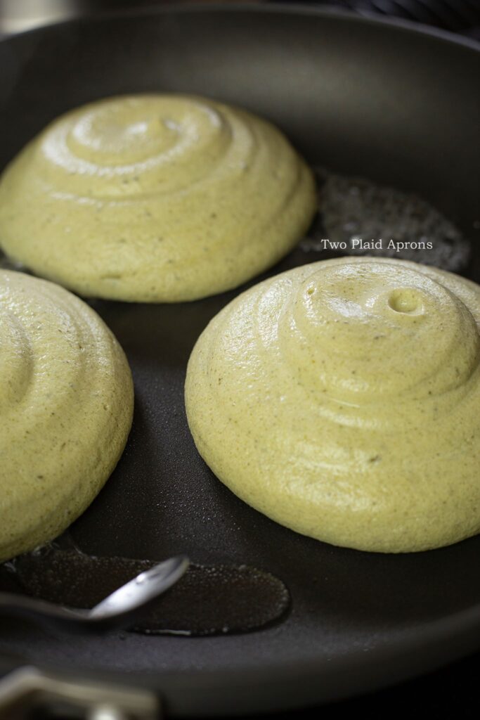 Matcha soufflé pancake batters in a nonstick pan with water.