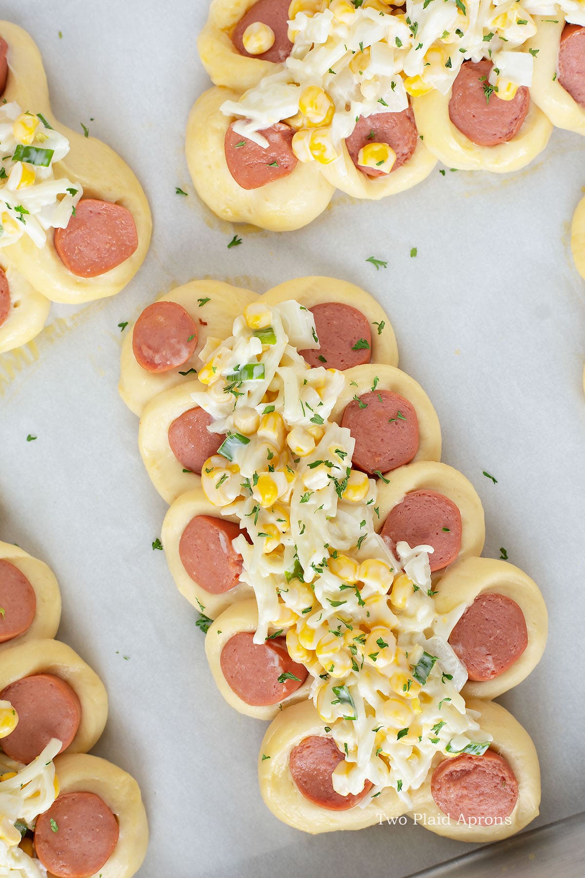 https://twoplaidaprons.com/wp-content/uploads/2020/08/sausage-bread-top-down-view-of-sausage-bread-with-toppings-and-parsley.jpg