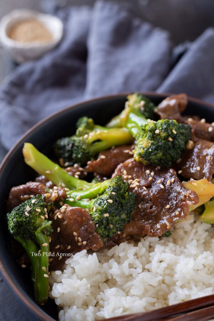Close up, angled view of beef and broccoli in a bowl with white rice.