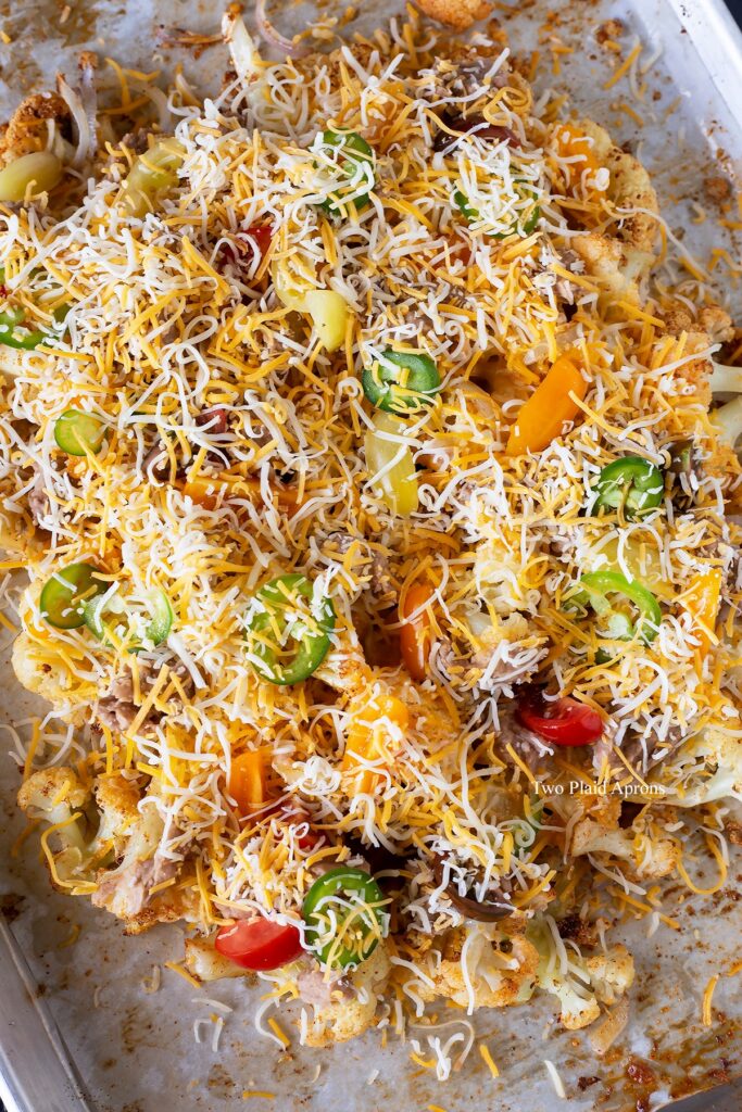 Top down view of cauliflower nachos dressed with all the toppings ready for baking.