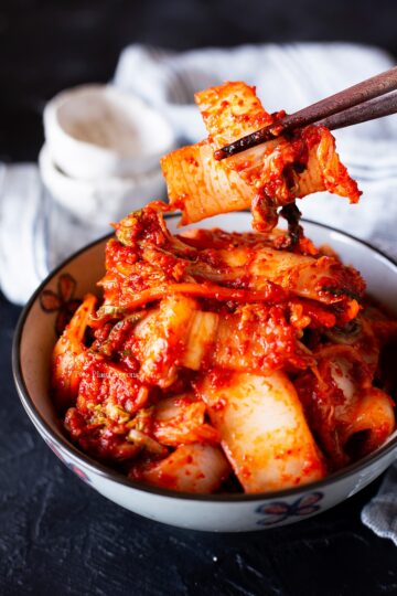 Picking up some of fresh kimchi (geotjeori) with chopsticks.