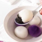 showing the black sesame filling flowing out of a half of an ube tang yuan.