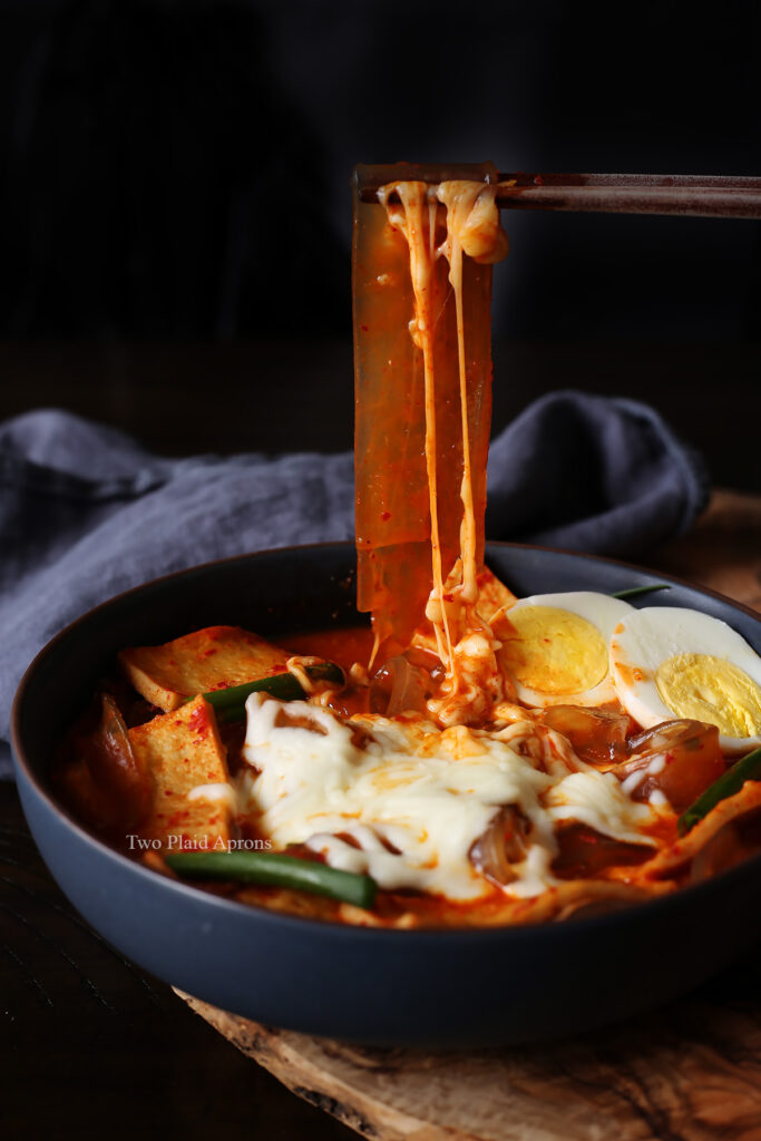 Pulling up a long strand of our healthier chewy vermicelli tteokbokki with cheese.