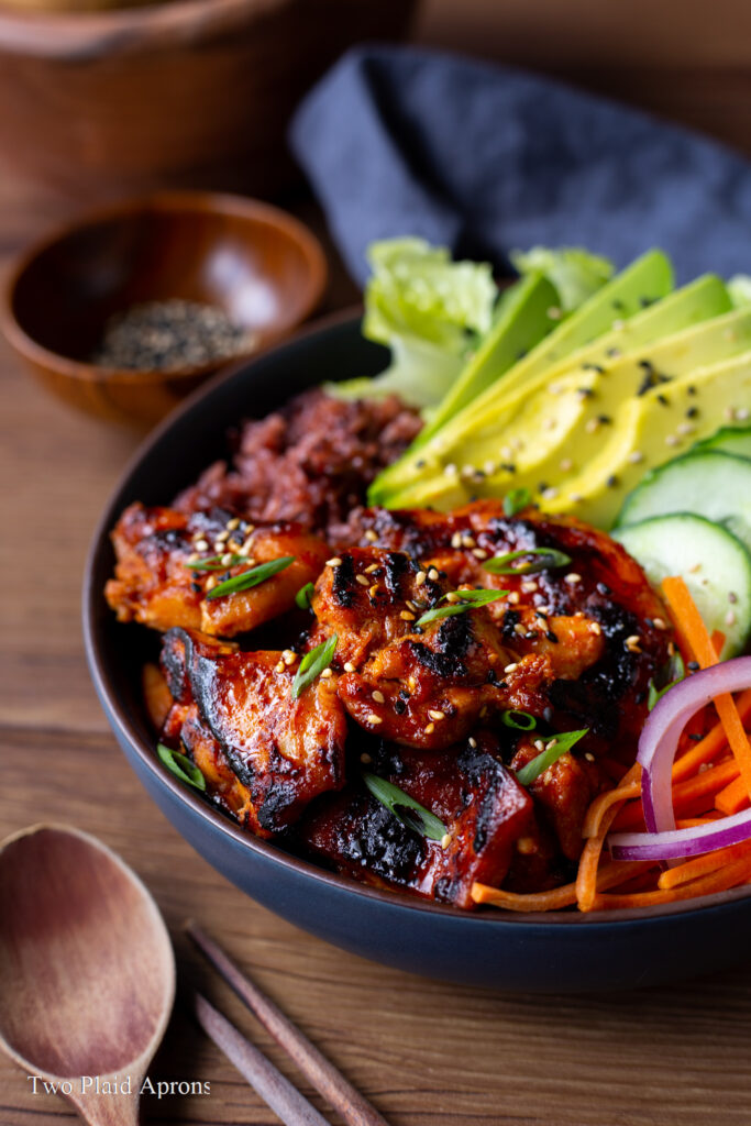 Side angle view of a spicy Korean chicken rice bowl.