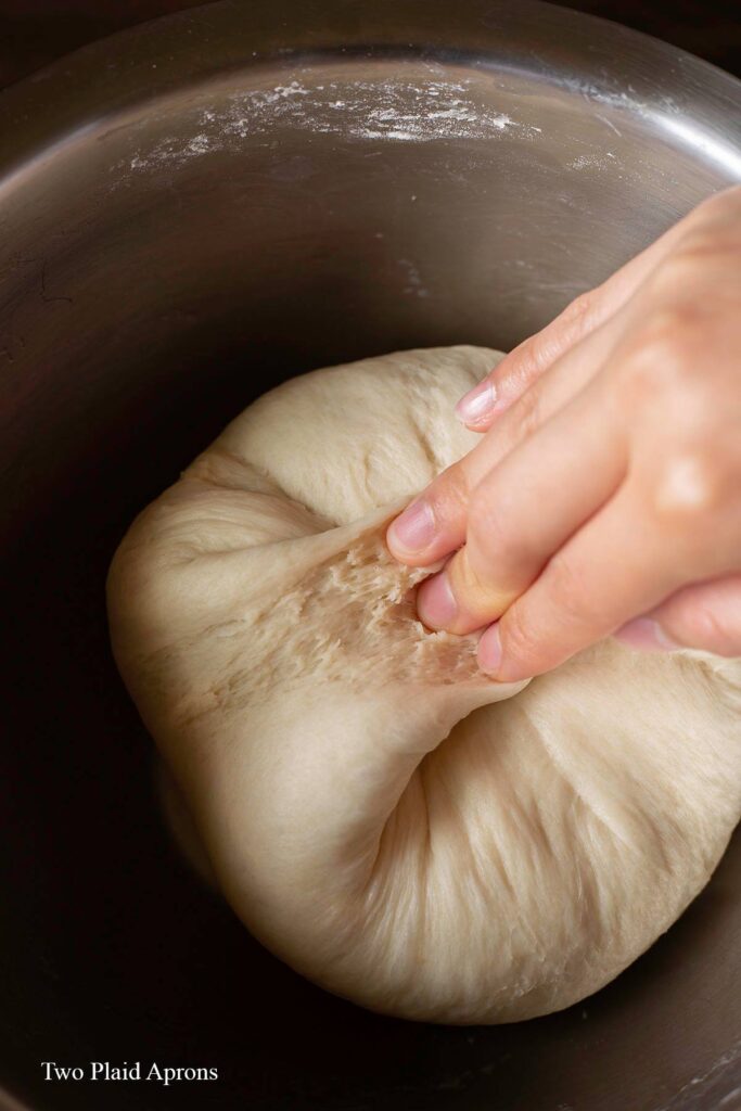 Kneading the dough by pulling the edge into the center.