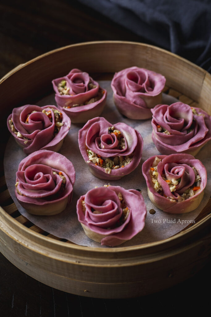 Top angled view of a basket of rose shaped dumplings before steaming.