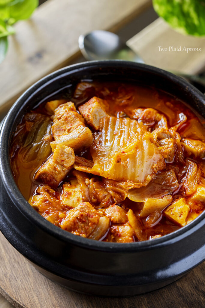 Close up view of the Instant Pot kimchi jjigae served in a stone bowl.