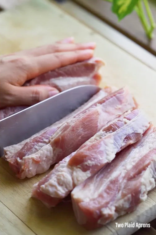 Slicing the pork belly into 1 inch slices to be cubed.