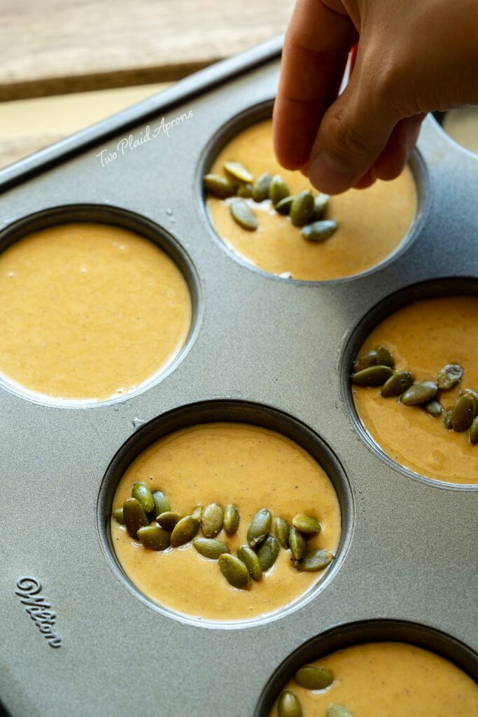 Garnishing mochi muffin batter with roasted pumpkin seeds.