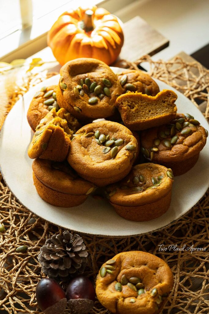 Pumpkin mochi muffins stacked on a plate.