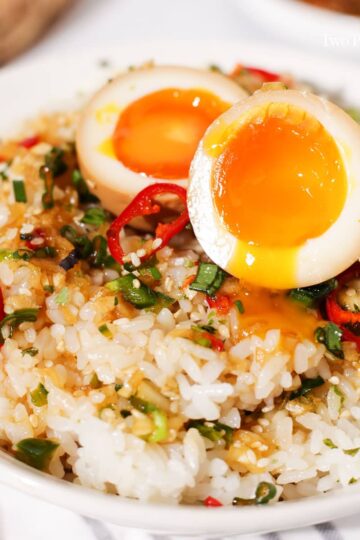A mayak egg cut in half on a bowl of rice.