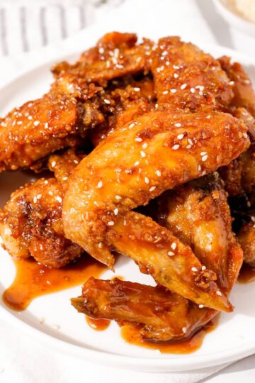 Air fryer honey garlic chicken wings garnished with sesame seeds.