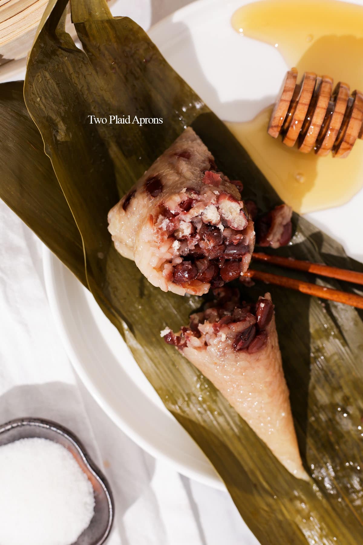 Zongzi with red bean cut in half on plate.