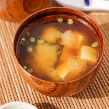 A bowl of miso soup garnished with green onions.