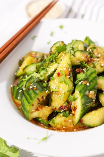 Chinese smashed cucumbers with cilantro in a plate.