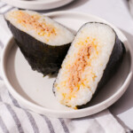 Spicy tuna onigiri cut in half on plate thumbnail.