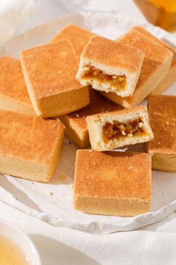 A plate of Chinese pineapple tarts with one cut in half.