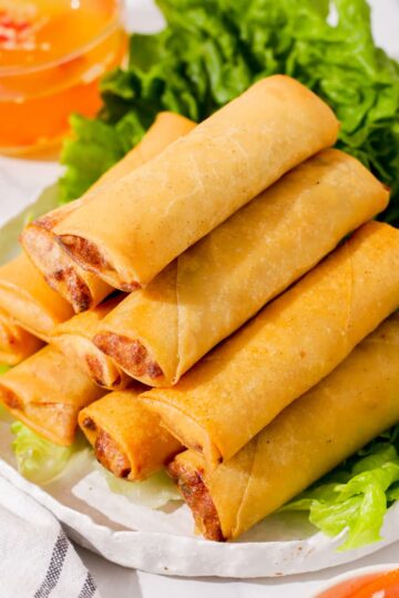 Vietnamese egg rolls stacked on plate.