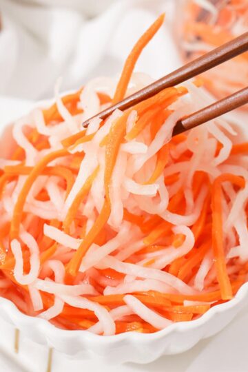 Picking up some đồ chua with chopsticks.