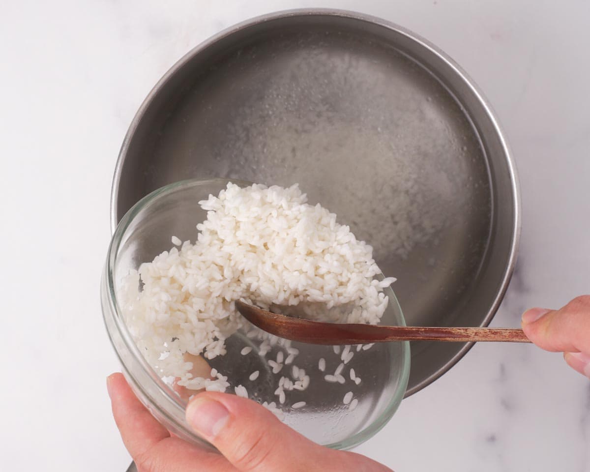 Placing rice in boiling water.