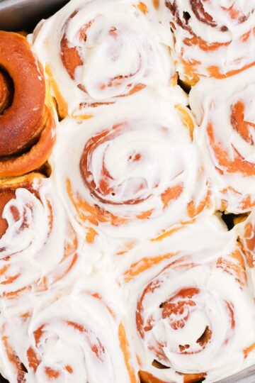 Top down pumpkin spiced cinnamon rolls with cream cheese icing thumbnail.